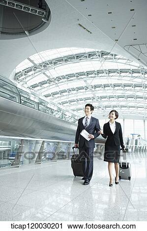 a businessman and woman walking together in Incheon airport View Large Photo Image Stock Image - a businessman and woman walking together in Incheon airport. Fotosearch