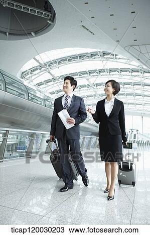 a businessman and woman walking together in Incheon airport View Large Photo Image Stock Image - a businessman and woman walking together in Incheon airport. Fotosearch