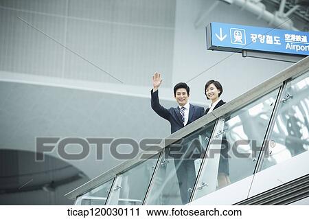 a businessman and woman waving at camera in Incheon airport View Large Photo Image Stock Image - a businessman and woman waving at camera in Incheon airport. Fotosearch