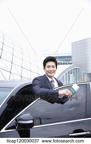 a businessman getting off a car holding a passport View Large Photo Image Stock Photo - a businessman getting off a car holding a passport. Fotosearch