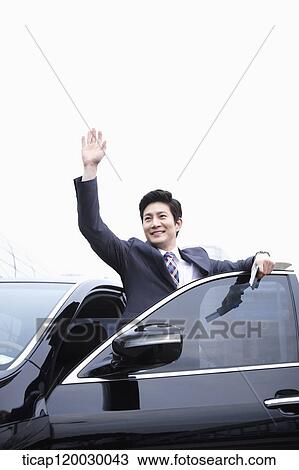 a businessman getting off a car waving while holding a passport View Large Photo Image Stock Image - a businessman getting off a car waving while holding a passport. Fotosearch