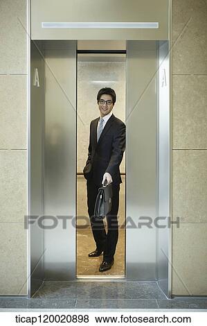 a businessman holding a bag between elevator doors View Large Photo Image Stock Photo - a businessman holding a bag between elevator doors . Fotosearch