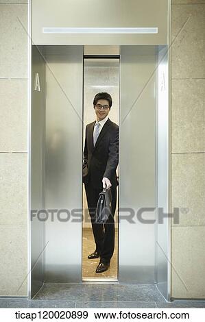 a businessman holding a bag between elevator doors View Large Photo Image Stock Photo - a businessman holding a bag between elevator doors . Fotosearch