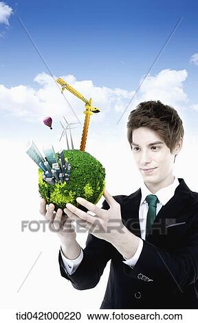 a businessman holding a globe with lifting crane View Large Photo Image Stock Image - a businessman holding a globe with lifting crane. Fotosearch