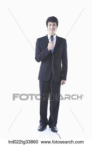 a businessman in a black suit holding a microphone View Large Photo Image Stock Image - a businessman in a black suit holding a microphone . Fotosearch