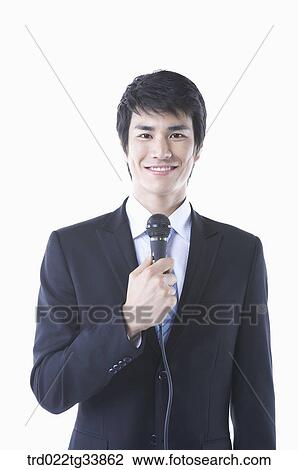 a businessman in a black suit holding a microphone smiling View Large Photo Image Stock Image - a businessman in a black suit holding a microphone smiling . Fotosearch