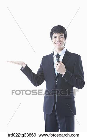 a businessman in a black suit explaining something using microphone View Large Photo Image Stock Photo - a businessman in a black suit explaining something using microphone . Fotosearch