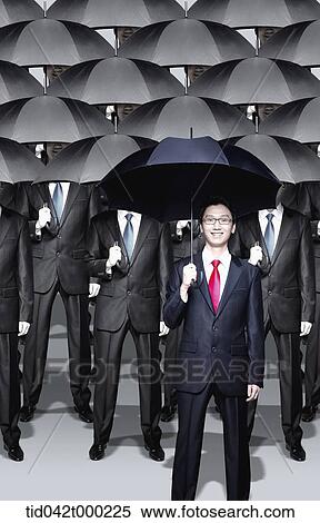 a businessman in front of group of businessmen with umbrellas View Large Photo Image Stock Photography - a businessman in front of group of businessmen with umbrellas . Fotosearch