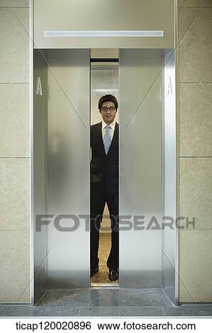 a businessman inside an opening elevator View Large Photo Image Stock Photograph - a businessman inside an opening elevator . Fotosearch