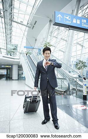 a businessman looking at his watch in a Incheon airport View Large Photo Image Stock Image - a businessman looking at his watch in a Incheon airport . Fotosearch