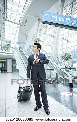 a businessman looking at his watch in a Incheon airport View Large Photo Image Stock Photography - a businessman looking at his watch in a Incheon airport . Fotosearch