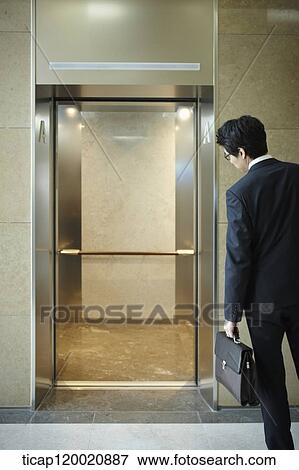 a businessman looking in an empty elevator View Large Photo Image Stock Photo - a businessman looking in an empty elevator. Fotosearch