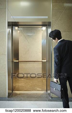 a businessman looking in an empty elevator View Large Photo Image Stock Photo - a businessman looking in an empty elevator. Fotosearch