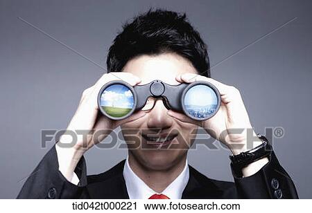 Stock Image - a businessman looking with a telescope. Fotosearch