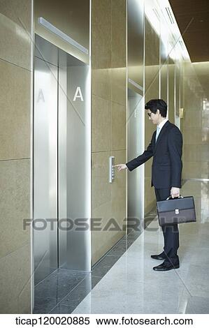 a businessman pressing button for an elevator in a office building View Large Photo Image Stock Photography - a businessman pressing button for an elevator in a office building. Fotosearch