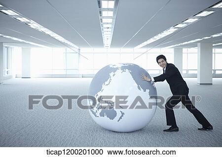 a businessman pushing a globe in an empty room View Large Photo Image Stock Image - a businessman pushing a globe in an empty room. Fotosearch