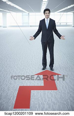 a businessman standing in the end of an arrow in an empty room View Large Photo Image Stock Photo - a businessman standing in the end of an arrow in an empty room. Fotosearch