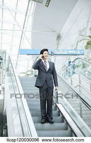 a businessman talking on the phone in escalator of Incheon airport View Large Photo Image Stock Photograph - a businessman talking on the phone in escalator of Incheon airport. Fotosearch