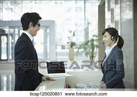 a businessman talking to a help desk in a office building View Large Photo Image Stock Image - a businessman talking to a help desk in a office building . Fotosearch