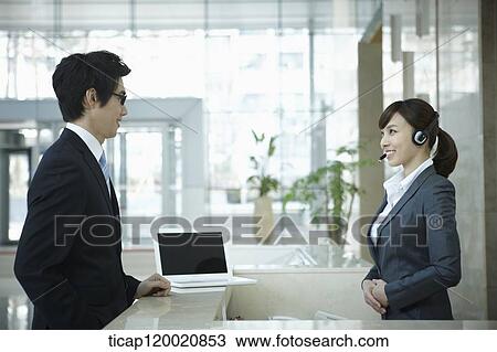 a businessman talking to a help desk in a office building View Large Photo Image Stock Image - a businessman talking to a help desk in a office building . Fotosearch