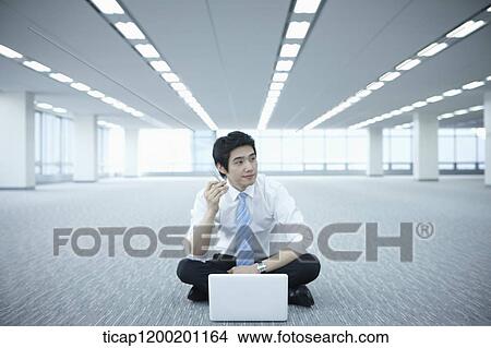 a businessman thinking while using laptop on the floor of an empty room View Large Photo Image Picture - a businessman thinking while using laptop on the floor of an empty room. Fotosearch