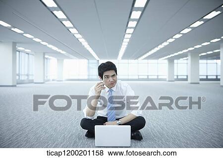 a businessman thinking while using laptop on the floor of an empty room View Large Photo Image Stock Photo - a businessman thinking while using laptop on the floor of an empty room. Fotosearch