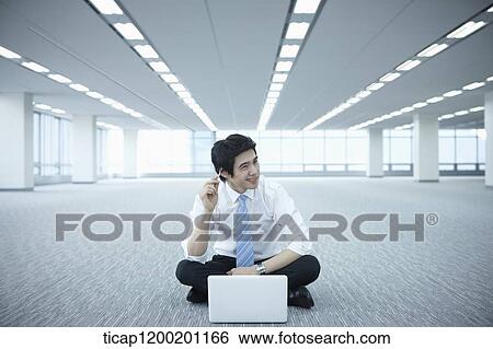 a businessman thinking while using laptop on the floor of an empty room View Large Photo Image Stock Photograph - a businessman thinking while using laptop on the floor of an empty room. Fotosearch