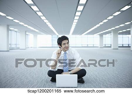 a businessman thinking while using laptop on the floor of an empty room View Large Photo Image Stock Photography - a businessman thinking while using laptop on the floor of an empty room. Fotosearch