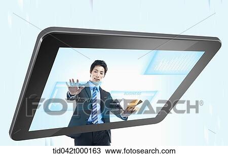 Stock Image - a businessman touching tablet screen. Fotosearch