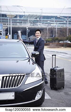 a businessman with a luggage opening a door of a car View Large Photo Image Stock Photography - a businessman with a luggage opening a door of a car. Fotosearch