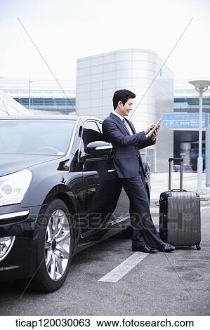 a businessman with a luggage waving hand while opening a door of a car View Large Photo Image Stock Image - a businessman with a luggage waving hand while opening a door of a car. Fotosearch