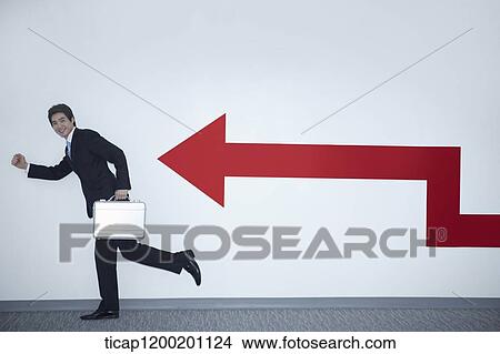 a businessman with running pose next to an arrow on the wall View Large Photo Image Picture - a businessman with running pose next to an arrow on the wall. Fotosearch