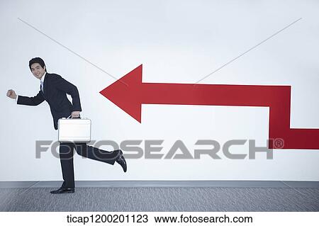 a businessman with running pose next to an arrow on the wall View Large Photo Image Stock Image - a businessman with running pose next to an arrow on the wall. Fotosearch