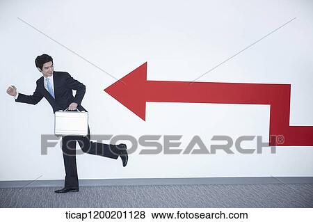 a businessman with running pose next to an arrow on the wall View Large Photo Image Stock Photo - a businessman with running pose next to an arrow on the wall. Fotosearch