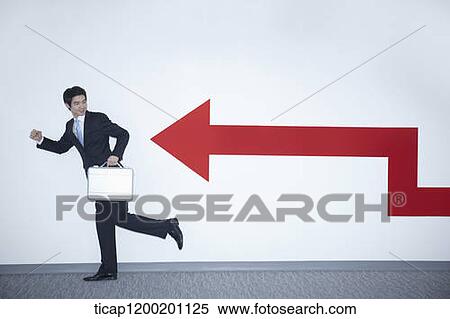 a businessman with running pose next to an arrow on the wall View Large Photo Image Stock Photography - a businessman with running pose next to an arrow on the wall. Fotosearch
