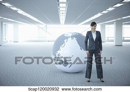 a businesswoman standing in an empty room in front of a huge globe View Large Photo Image Stock Image - a businesswoman standing in an empty room in front of a huge globe. Fotosearch