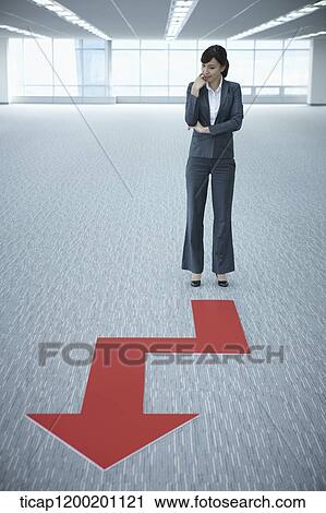 a businesswoman standing in front of an arrow in an empty room View Large Photo Image Stock Image - a businesswoman standing in front of an arrow in an empty room. Fotosearch