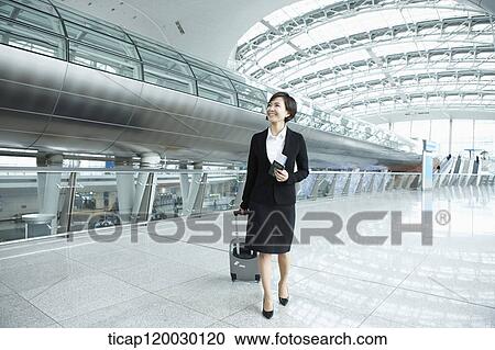 a businesswoman walking with luggage in Incheon airport View Large Photo Image Stock Image - a businesswoman walking with luggage in Incheon airport. Fotosearch