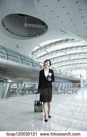 a businesswoman walking with luggage in Incheon airport View Large Photo Image Stock Image - a businesswoman walking with luggage in Incheon airport. Fotosearch