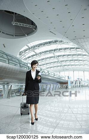 a businesswoman walking with luggage in Incheon airport View Large Photo Image Stock Photography - a businesswoman walking with luggage in Incheon airport. Fotosearch