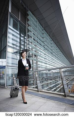 a businesswoman with a luggage and a passport walking in Incheon airport View Large Photo Image Picture - a businesswoman with a luggage and a passport walking in Incheon airport. Fotosearch