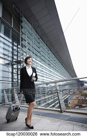 a businesswoman with a luggage and a passport walking in Incheon airport View Large Photo Image Stock Photograph - a businesswoman with a luggage and a passport walking in Incheon airport. Fotosearch