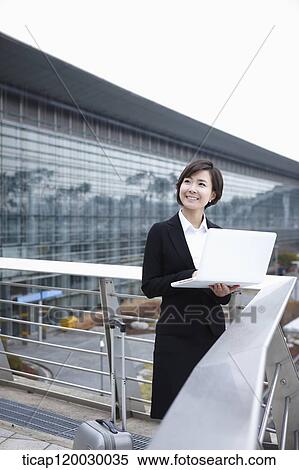 a businesswoman with a luggage working on laptop in Incheon airport View Large Photo Image Stock Photography - a businesswoman with a luggage working on laptop in Incheon airport. Fotosearch