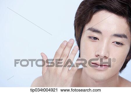 Stock Image - a close up shot of a topless man about to put on lotion. Fotosearch