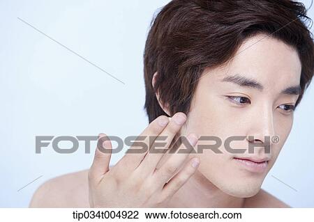 Stock Image - a close up shot of a topless man about to put on lotion. Fotosearch