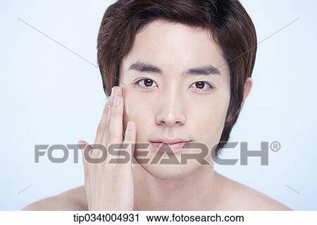 Stock Image - a close up shot of a topless man putting on lotion. Fotosearch