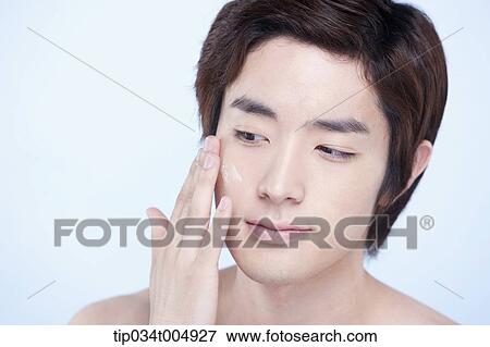 Stock Photo - a close up shot of a topless man putting on lotion. Fotosearch