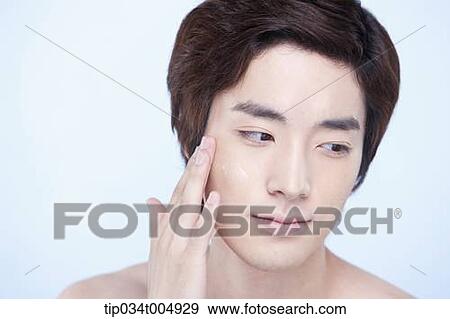 Stock Photo - a close up shot of a topless man putting on lotion. Fotosearch