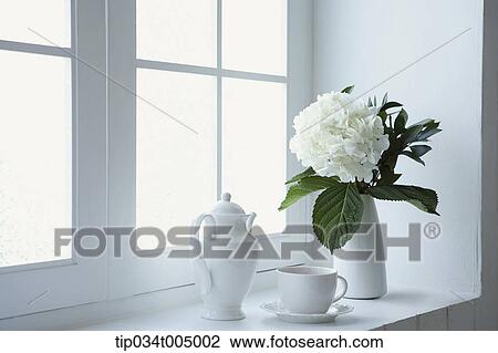 a coffee pot and a mug placed with a vase with flower by a window View Large Photo Image Stock Image - a coffee pot and a mug placed with a vase with flower by a window. Fotosearch