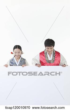 Stock Image - a couple in Hnabok holding an empty whiteboard. Fotosearch